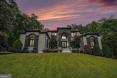The same house at dusk with lights on